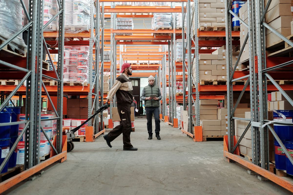 Warehouse workers managing stock in an aisle