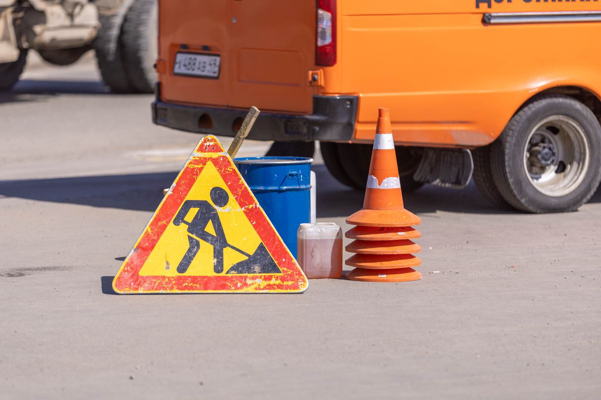 Roadwork sign and traffic safety equipment on asphalt
